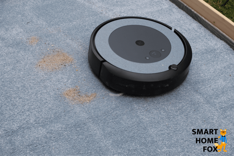 Sand wird auf einem hochflorigen Teppich durch den iRobot Roomba i3 gereinigt